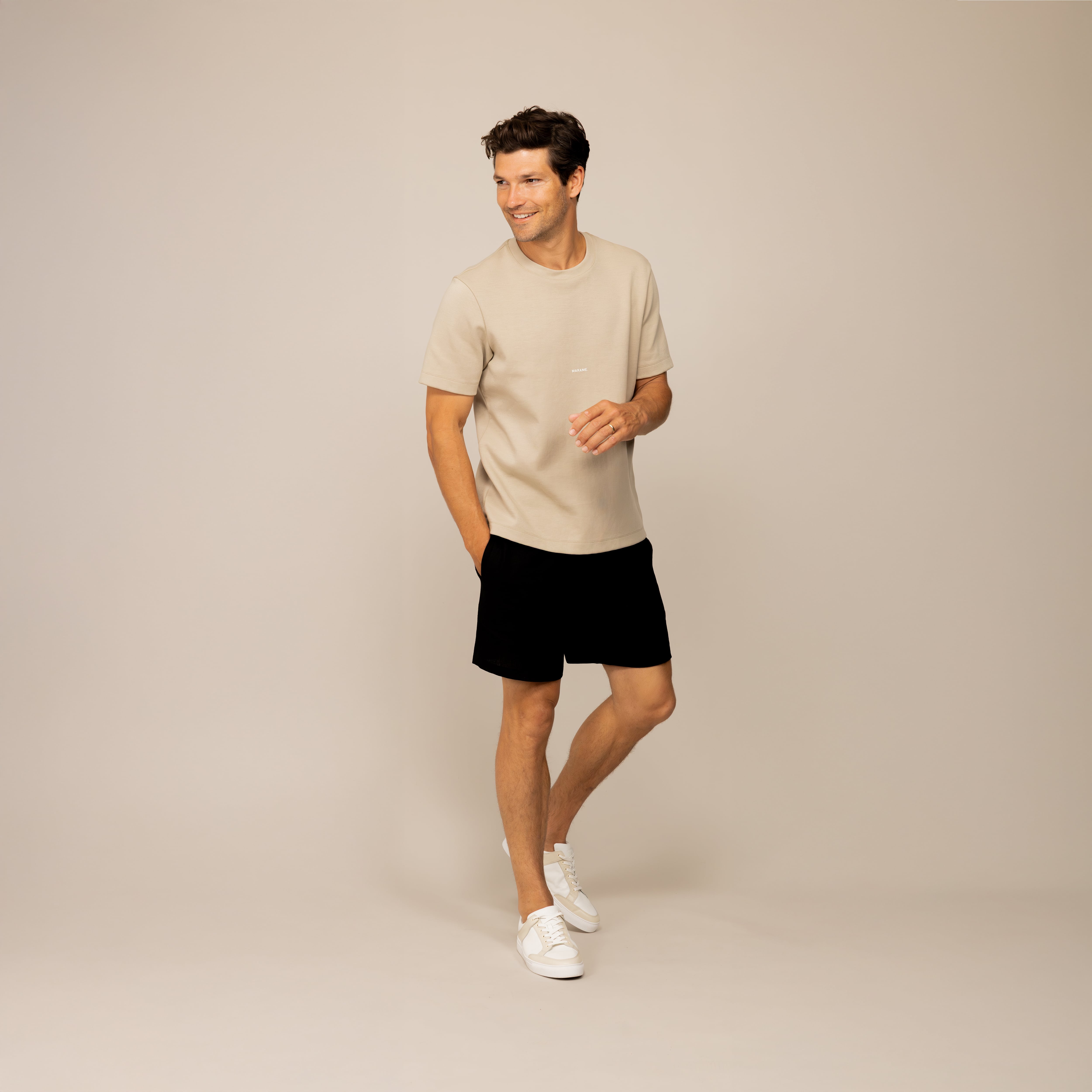 Man wearing black casual linen blend shorts, front view.