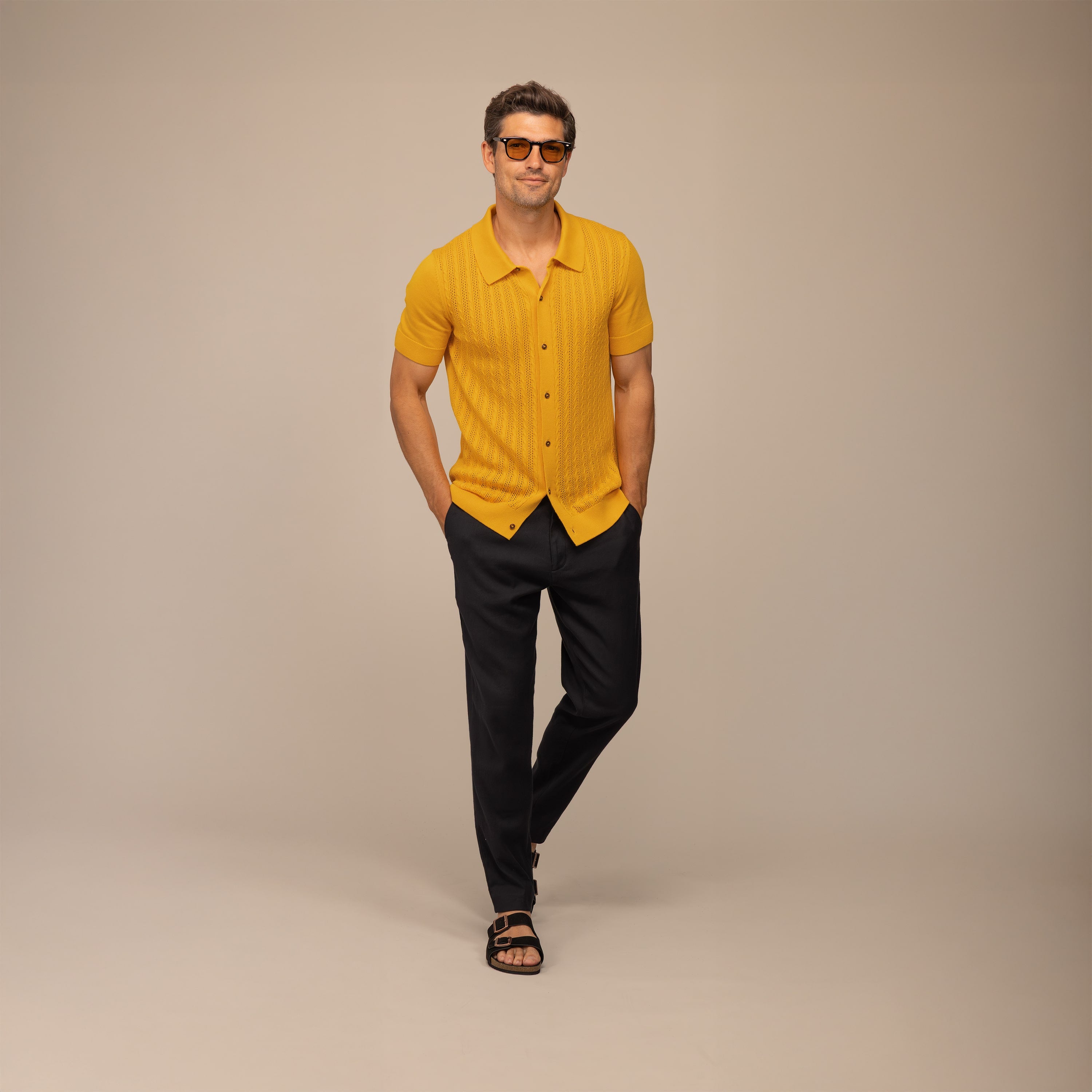 Bold summer dinner outfit featuring a citrus short sleeve knit shirt and tailored black linen trousers, styled for a refined evening look