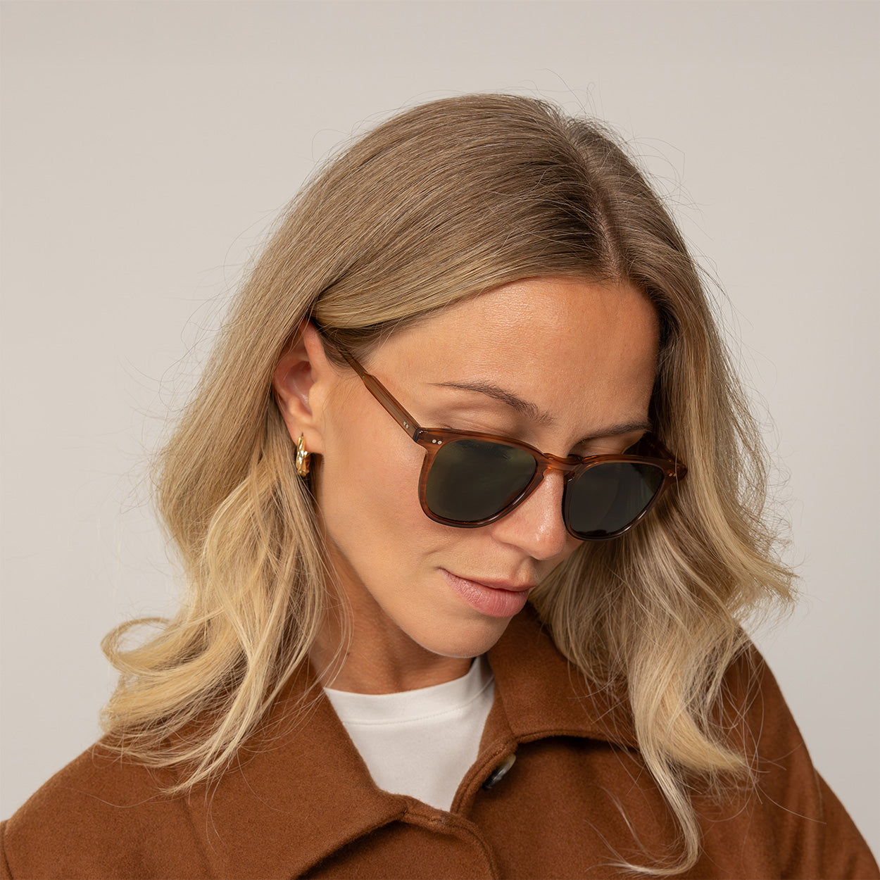 Woman wearing Garrett Leight Brooks Sun Sunglasses in Pacific Teak, front view.