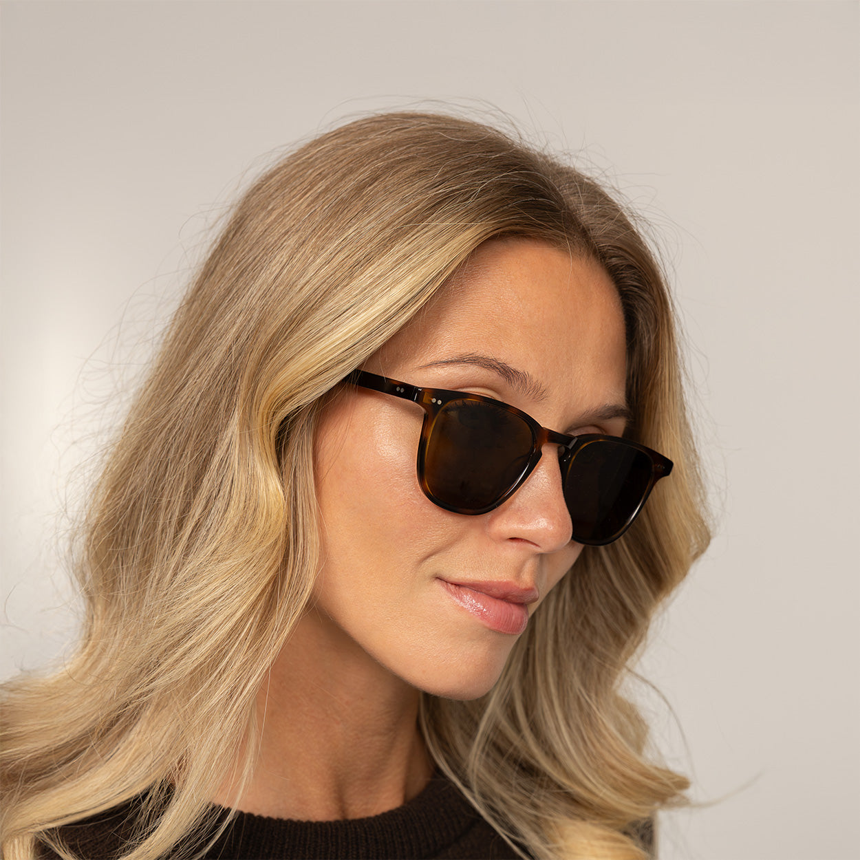 Woman wearing Garrett Leight Brooks Sun Sunglasses in Spotted Brown Shell, front view.