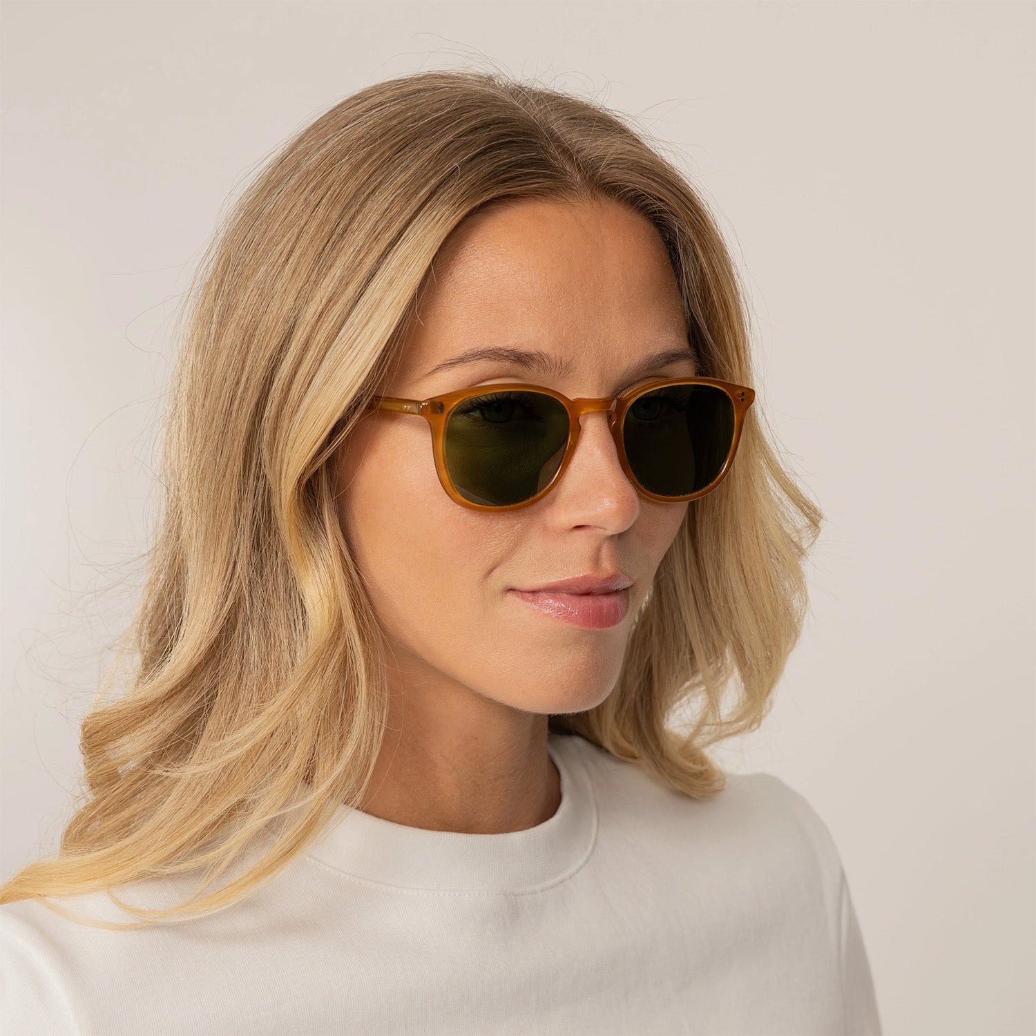 Woman wearing Garrett Leight Kinney Sun Sunglasses in Butterscotch, front view.