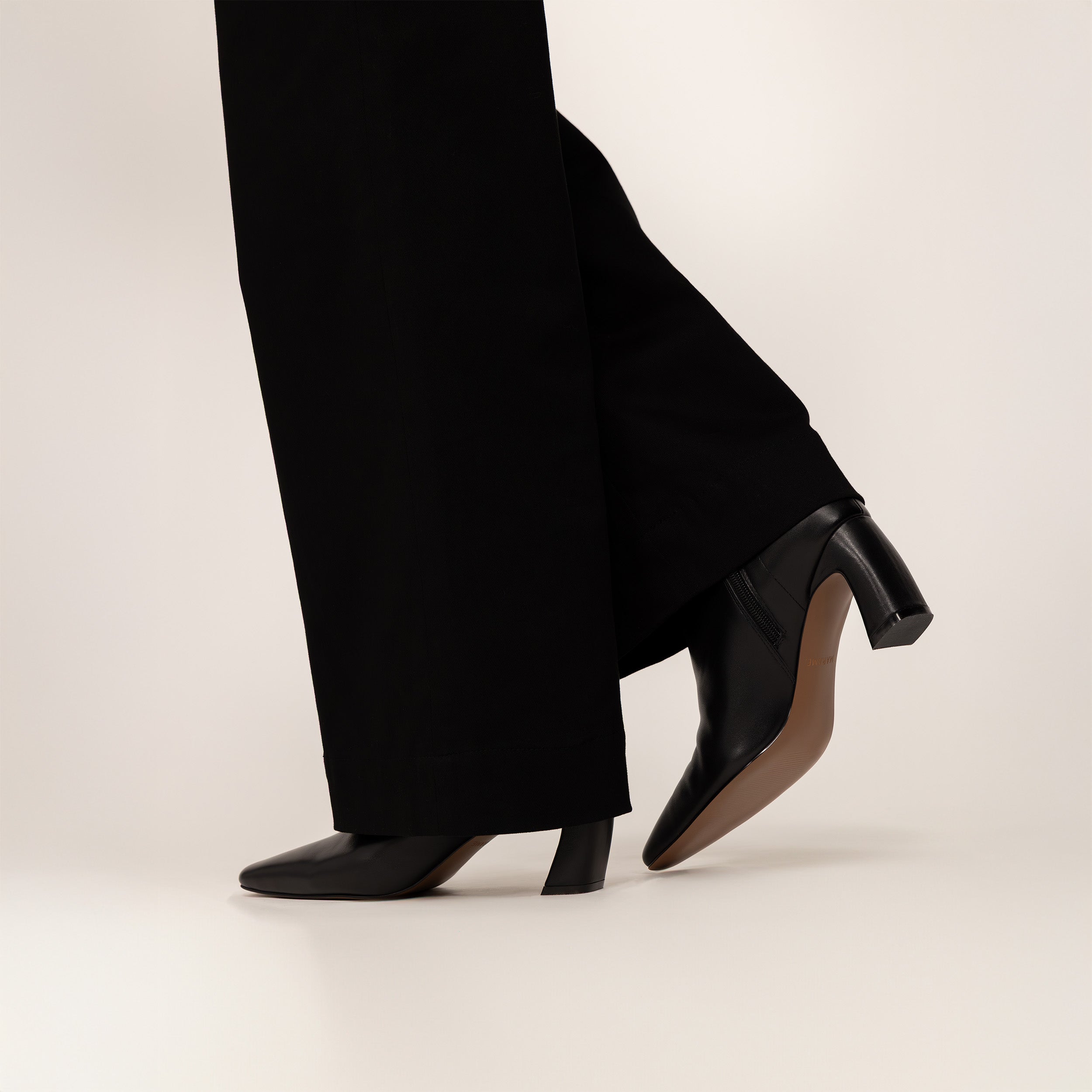 woman wearing Marame Leather Ankle Boots in Black, side view.