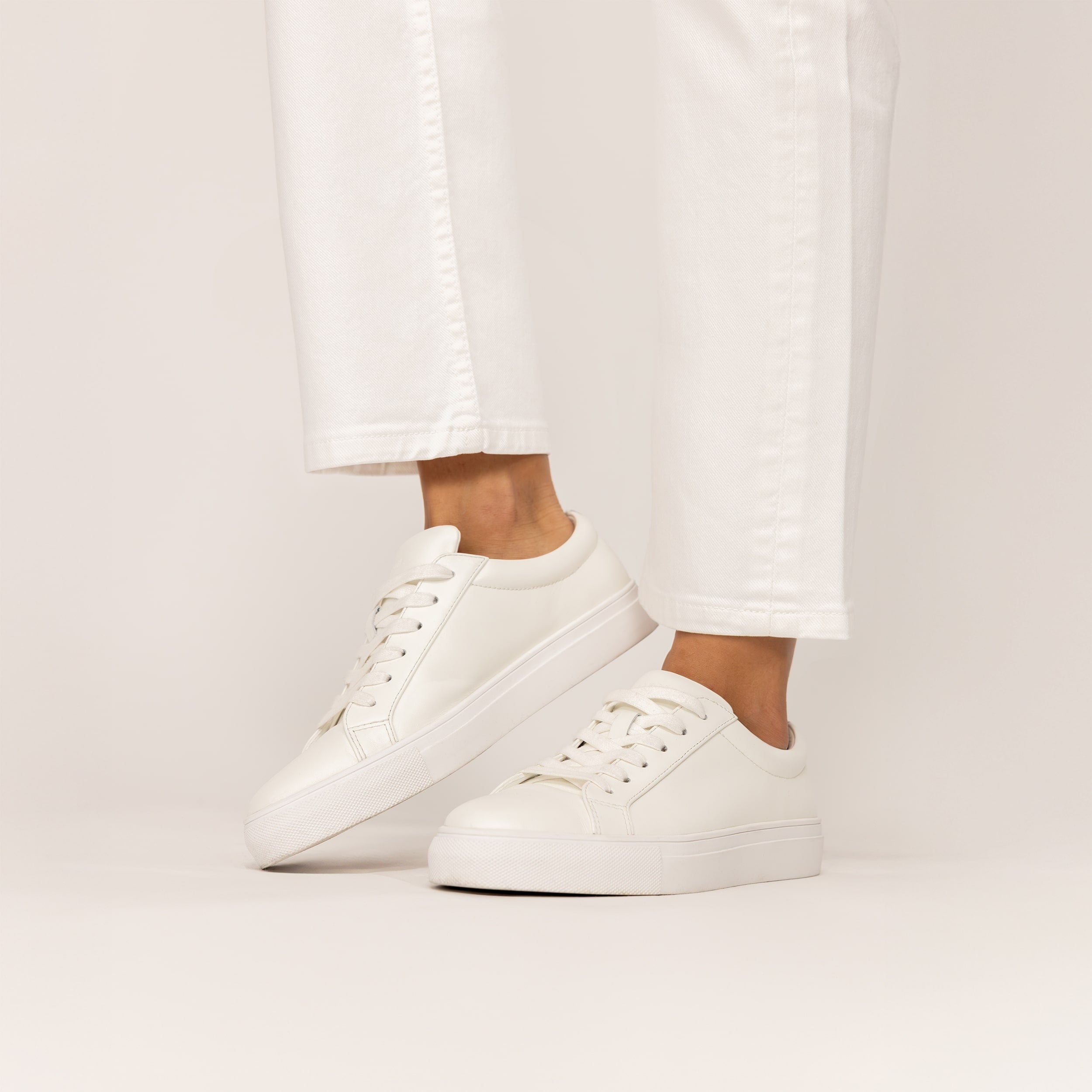 Woman wearing Marame Smart Leather Trainers in White, front view.