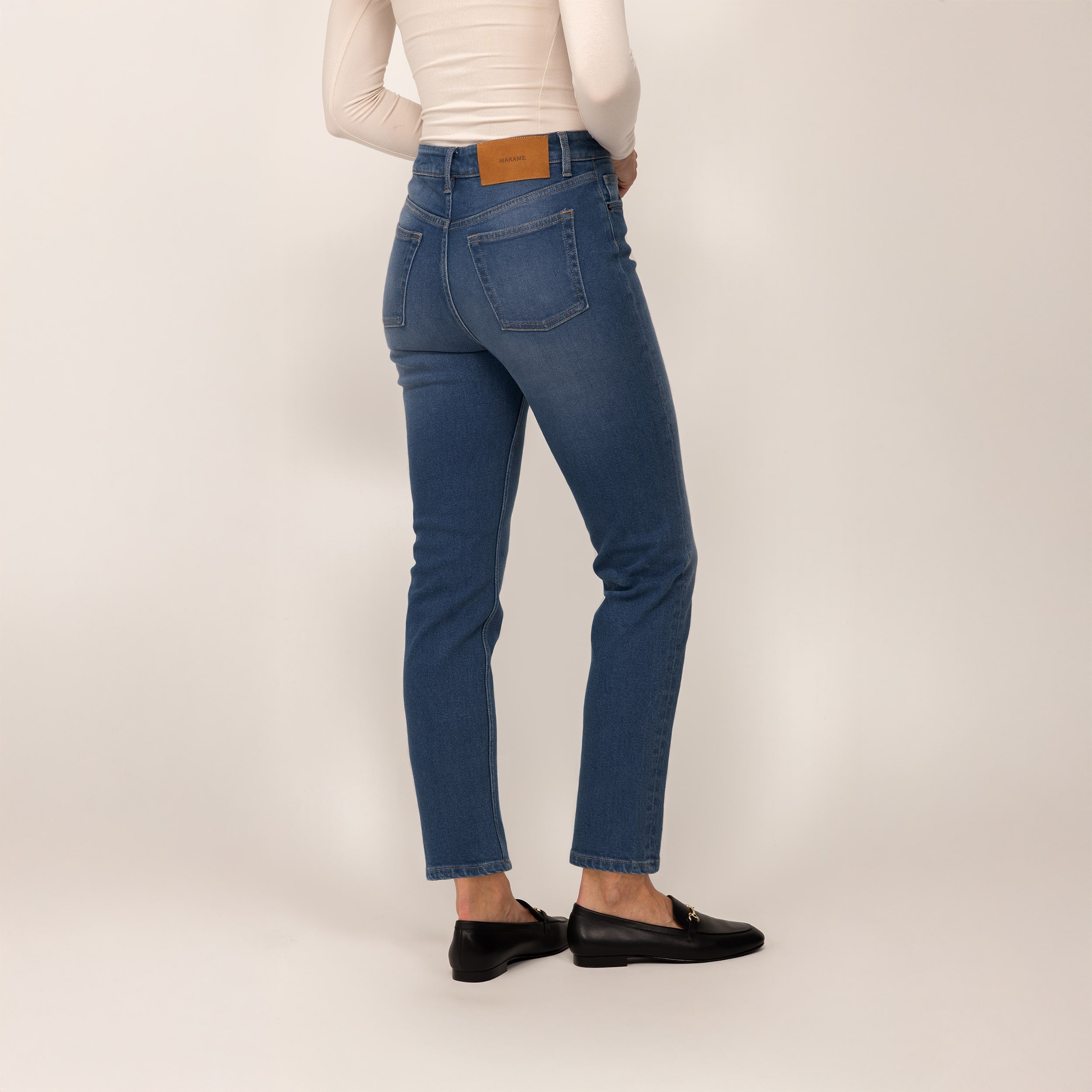 Woman wearing Marame Straight Leg Jeans in Deep Navy Wash Denim, rear view.