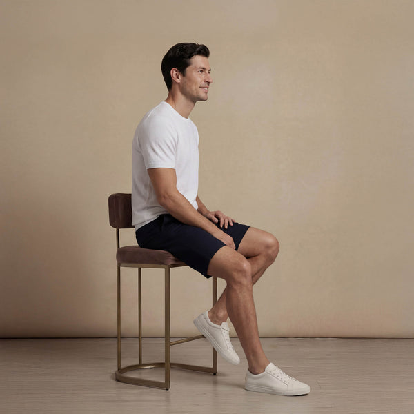 Man wearing Marame Chino Shorts in navy, seated view. |navy