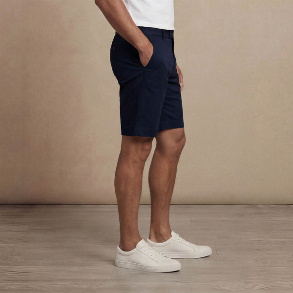 Man wearing Marame Chino Shorts in navy, side view. |navy
