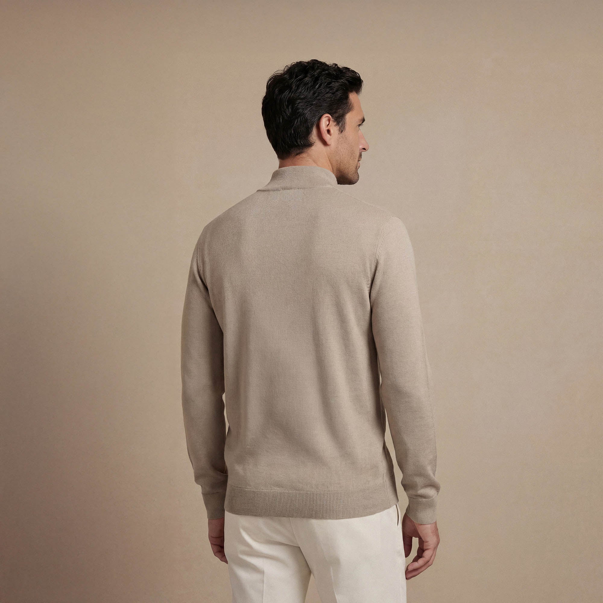 Man wearing a navy half zip jumper, back view. |putty dove