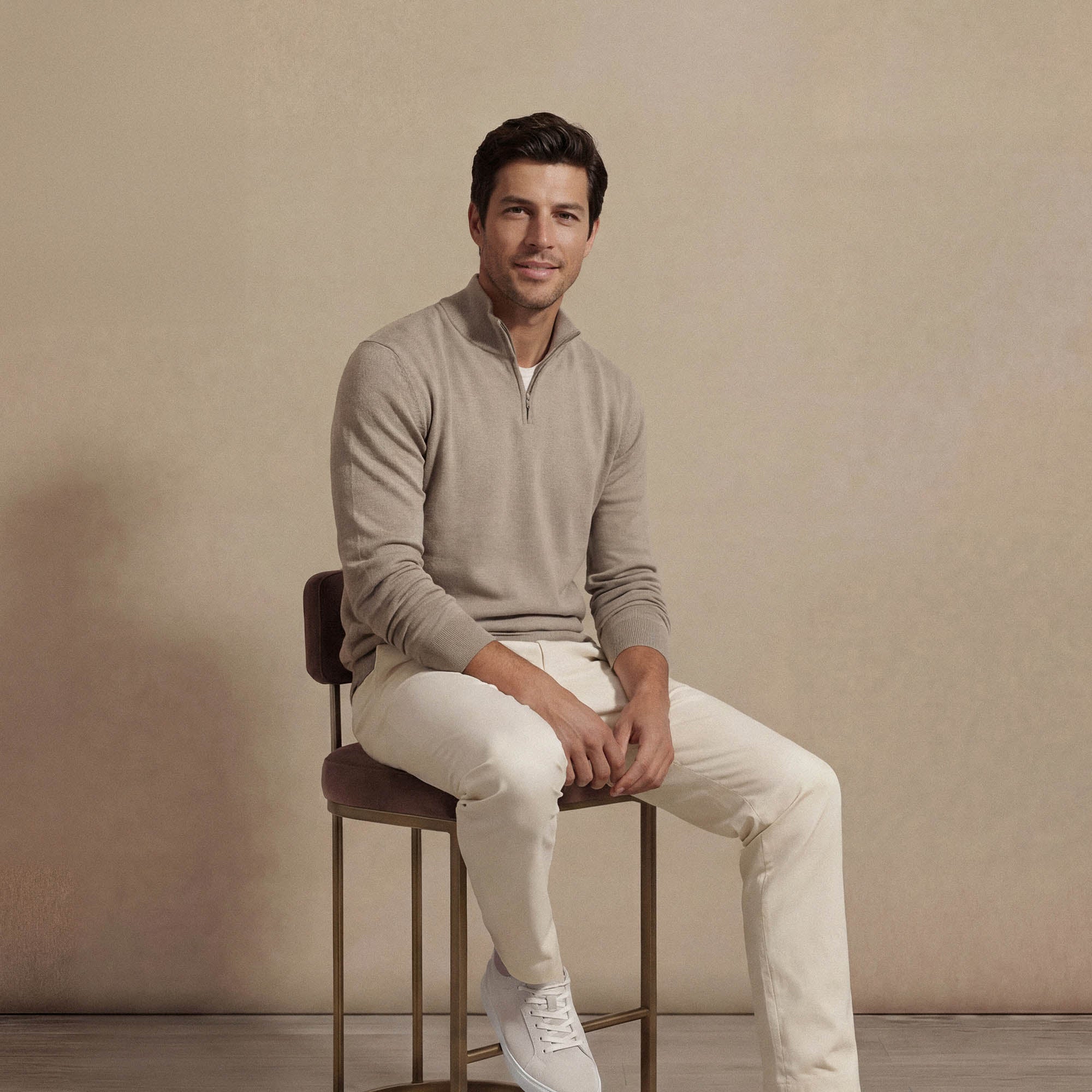 Man wearing a navy half zip jumper, seated view. |putty dove