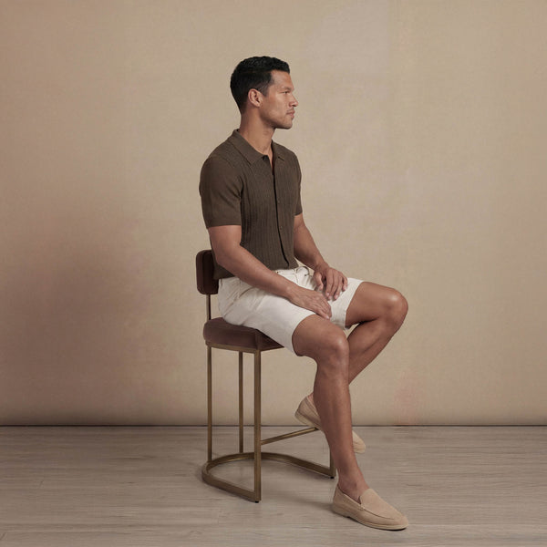 Man wearing morning meadow cable knit short sleeve shirt, seated view. |morning meadow