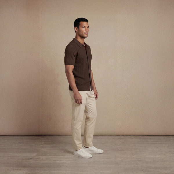 Man wearing Marame cable knit shirt in conker brown, side view. |conker brown