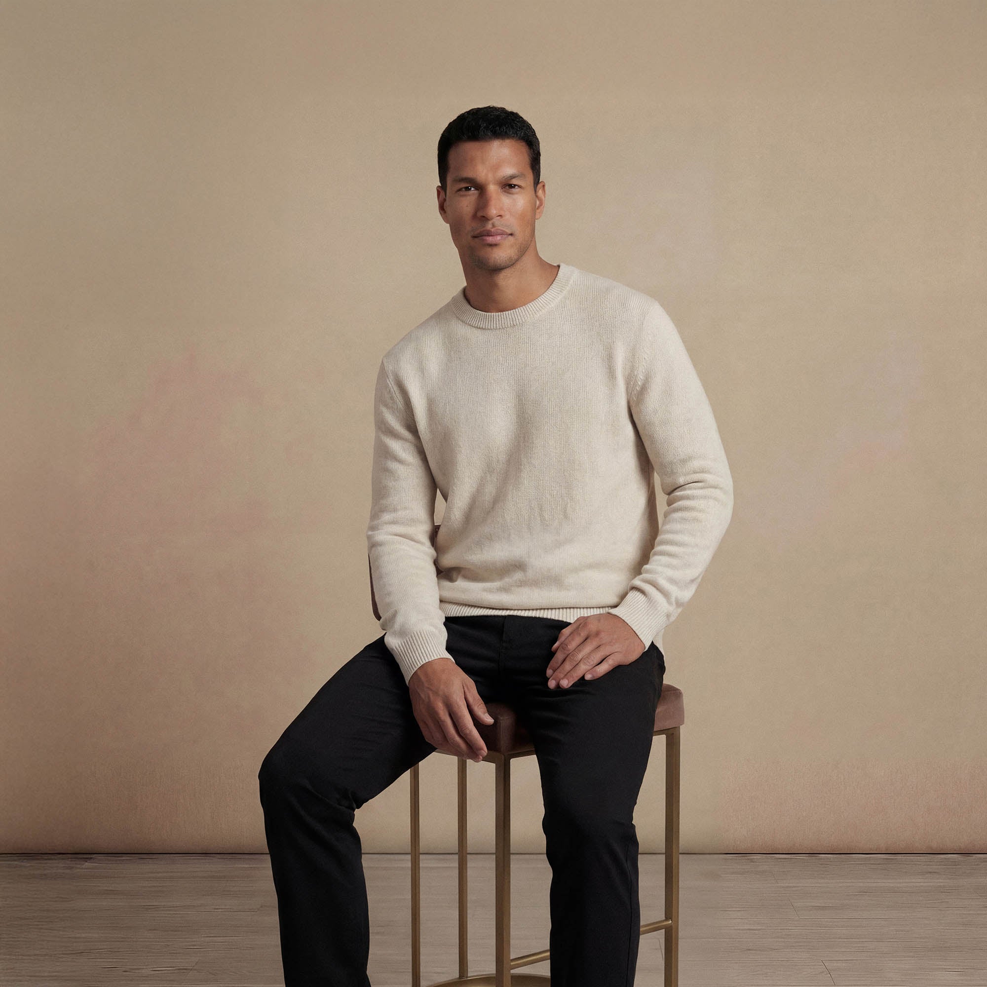 Man wearing a Marame Merino Wool Crew Neck Knit Jumper in seated view.|speckled grey