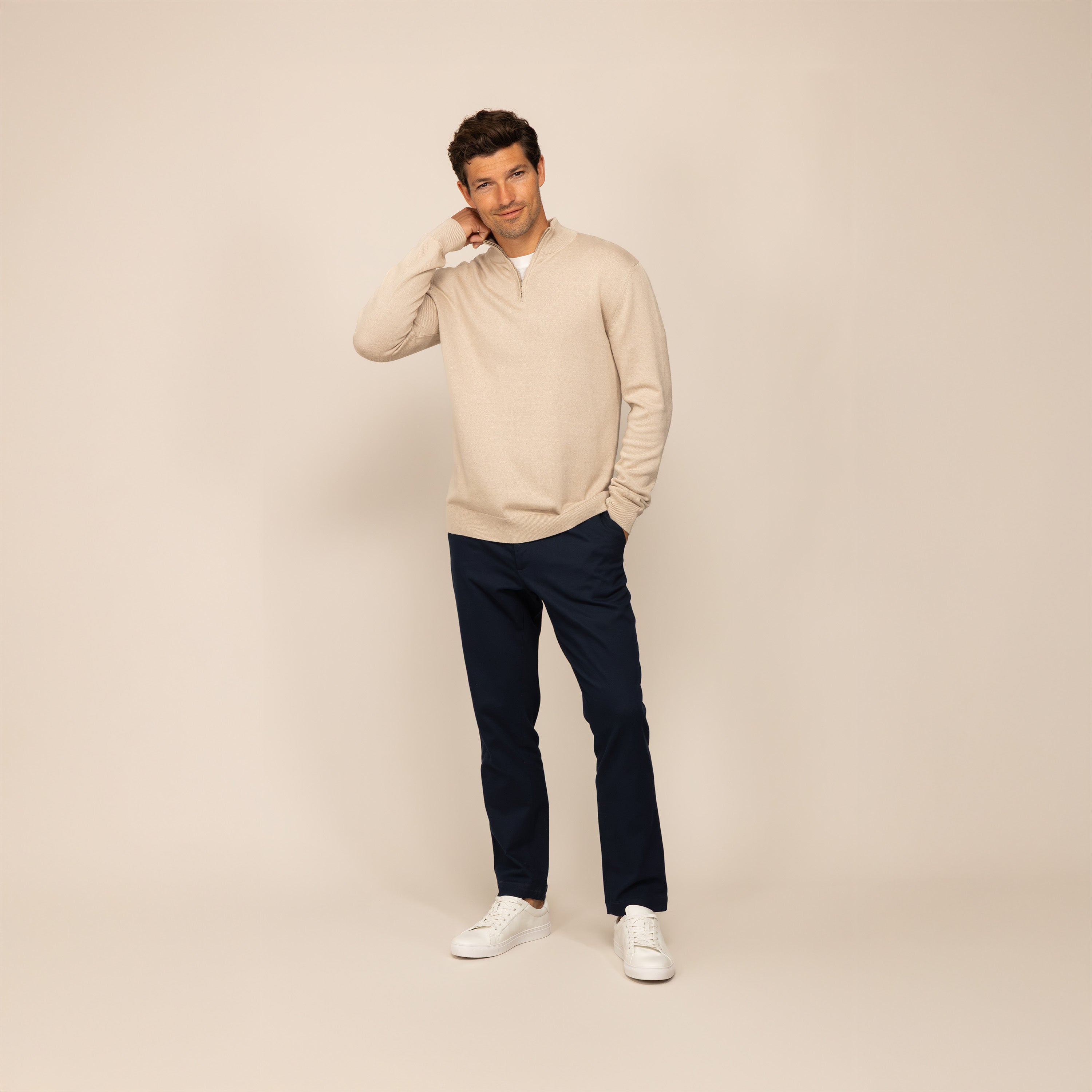 Man wearing a beige pearl half zip jumper, front view.