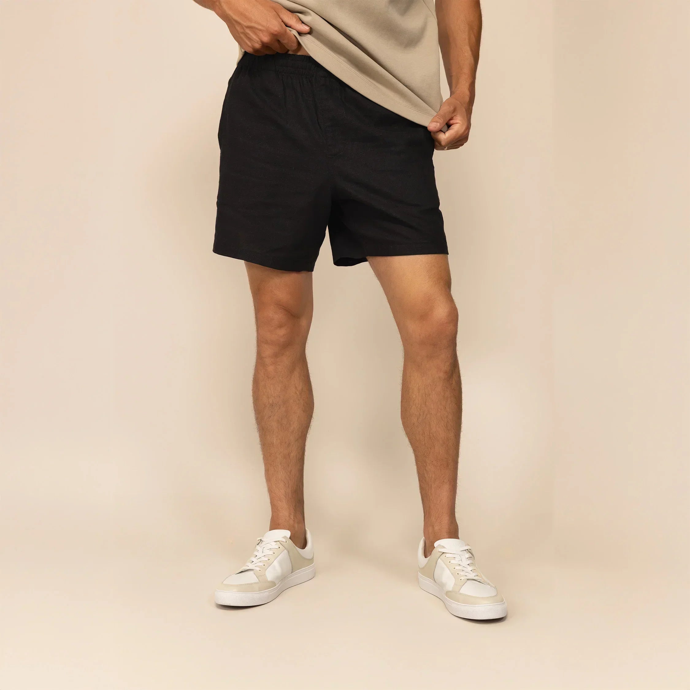 Man wearing black casual linen blend shorts, front view. |black
