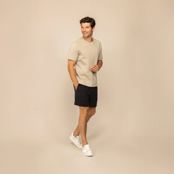 Man wearing black casual linen blend shorts, front view.