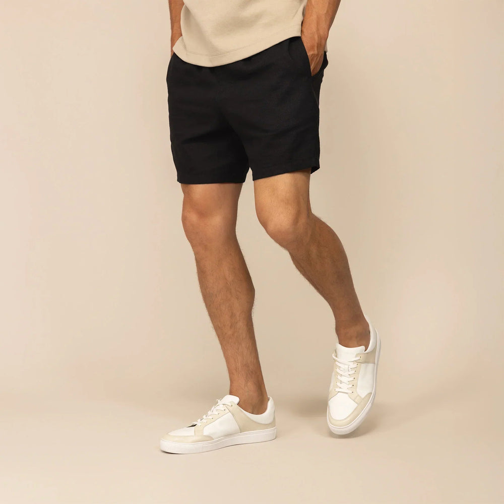 Man wearing black casual linen blend shorts, front view. |black