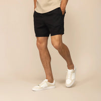 Man wearing black casual linen blend shorts, front view. |black