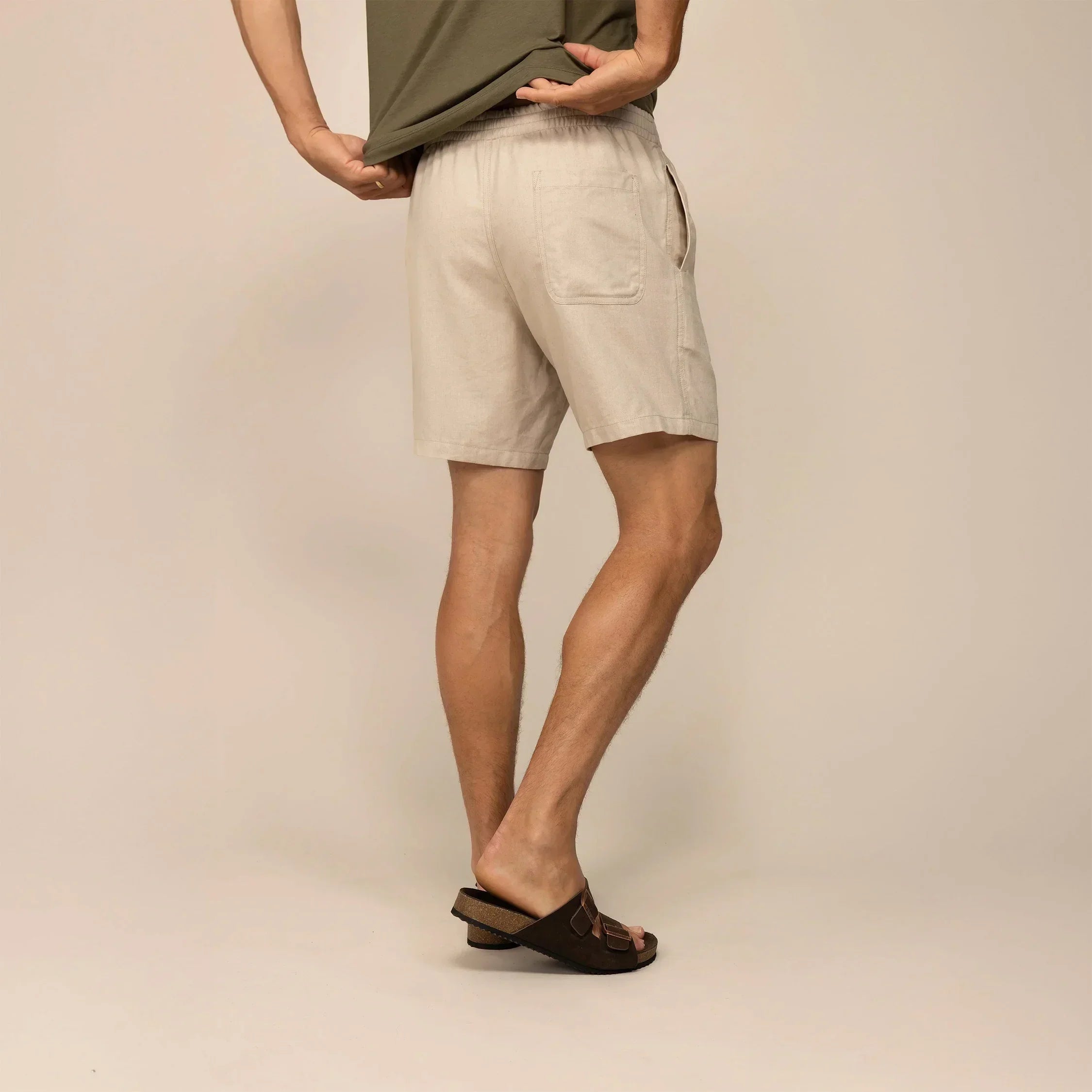 Man wearing casual linen blend shorts in natural sand, rear view. |natural sand