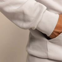 Man wearing a cotton fleece hoodie in Ash White, closeup.