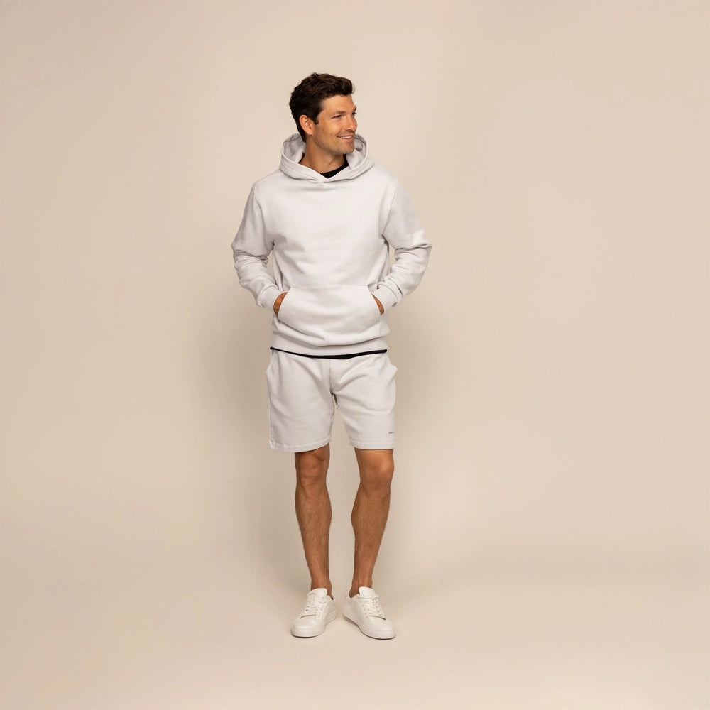 Man wearing a Marame cotton fleece hoodie in Ash White, full view.