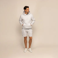 Man wearing a Marame cotton fleece hoodie in Ash White, full view.