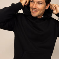 Man wearing a Marame cotton fleece hoodie in Black, closeup.