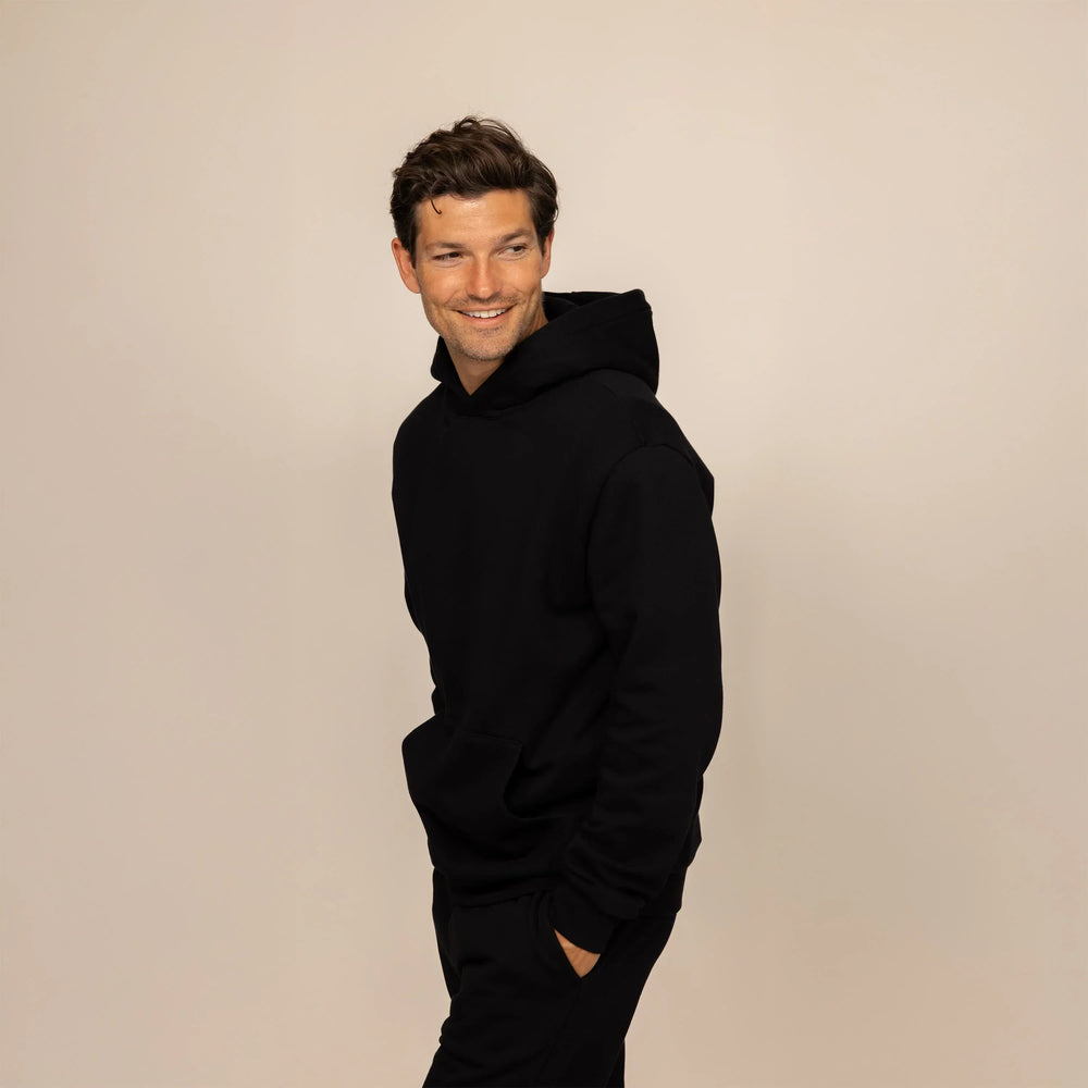 Man wearing a Marame cotton fleece hoodie in Black, front view.