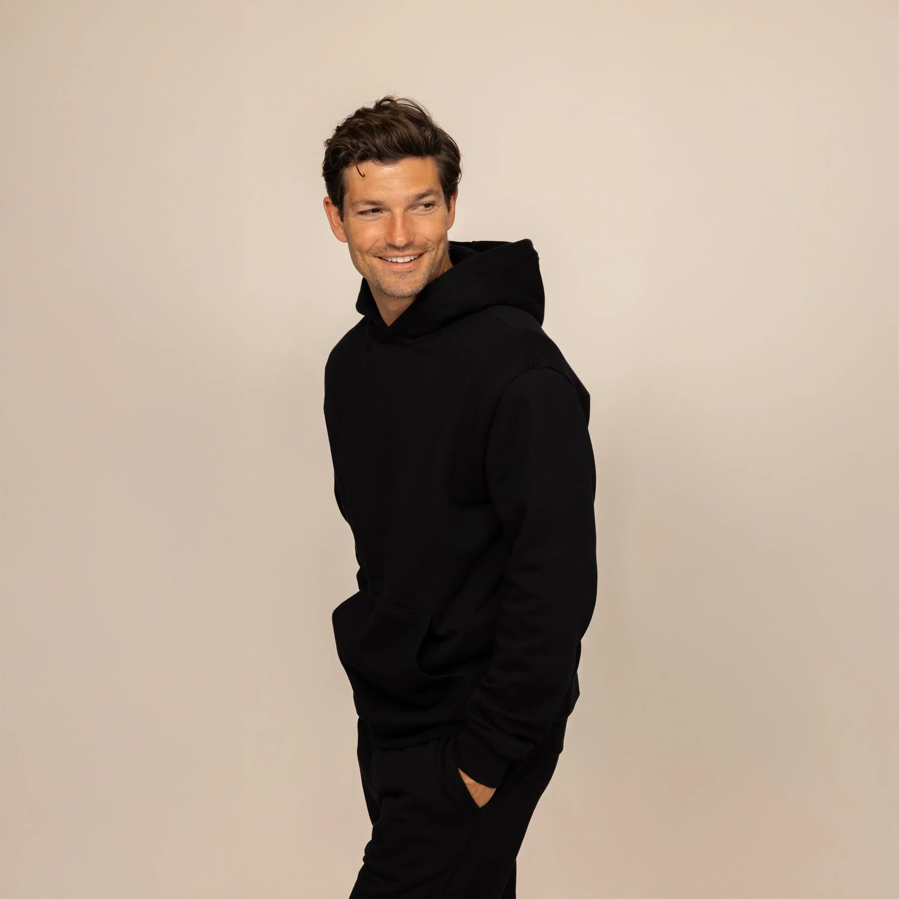 Man wearing a Marame cotton fleece hoodie in Black, front view.|black
