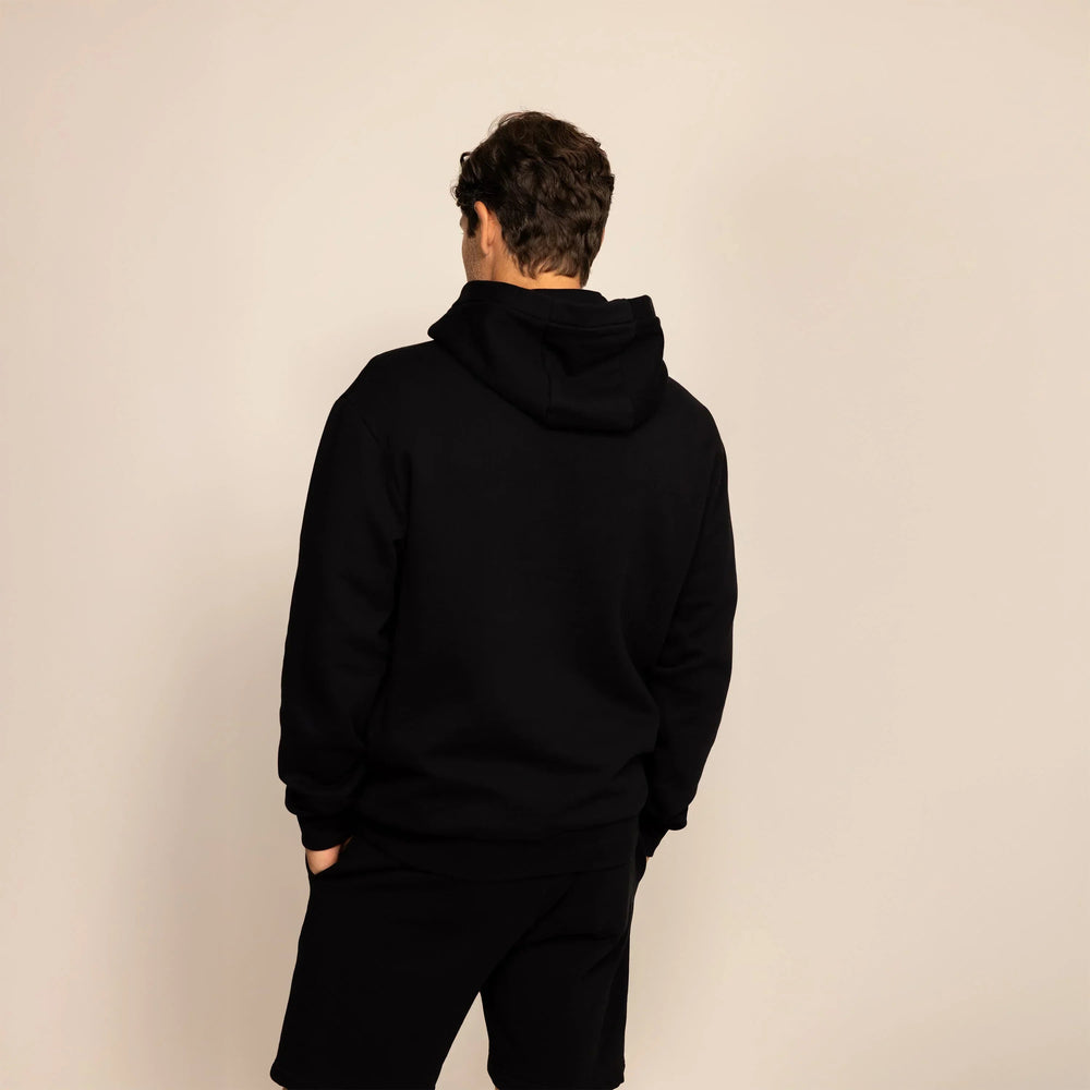 Man wearing a Marame cotton fleece hoodie in Black, rear view.|black