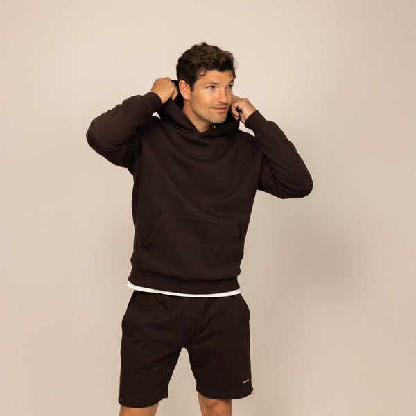 Man wearing a cotton fleece hoodie in Smoked Brown, front view.