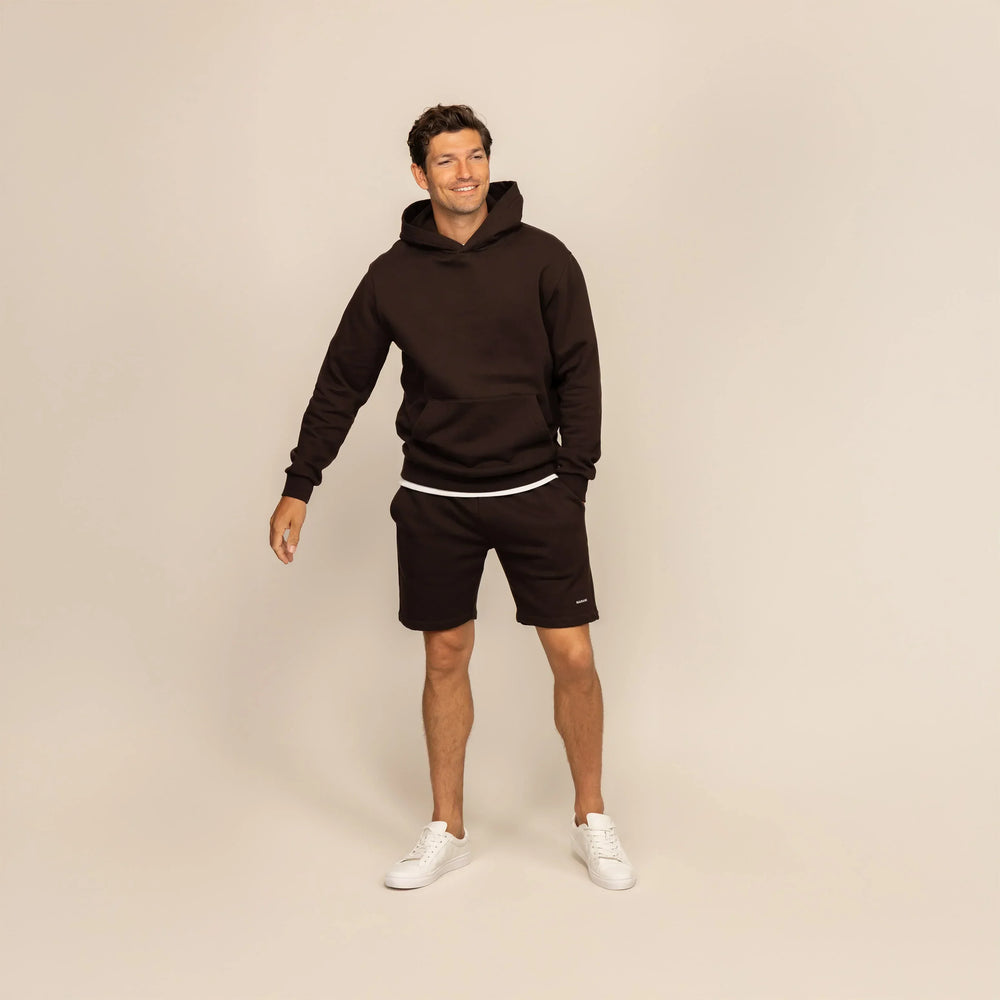 Man wearing a Marame cotton fleece hoodie in Smoked Brown, full view.