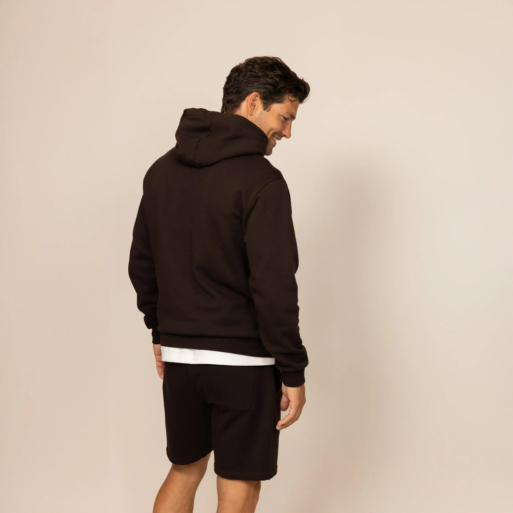 Man wearing a cotton fleece hoodie in Smoked Brown, rear view.