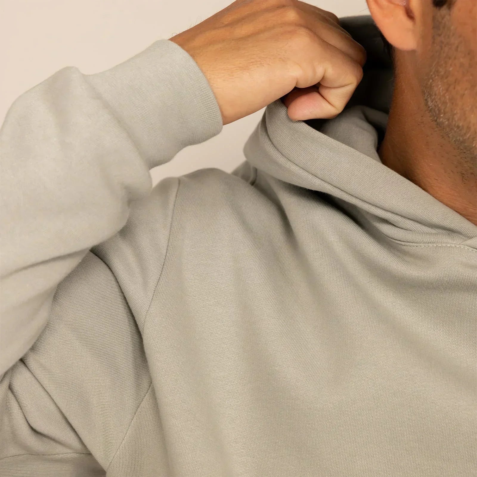 Man wearing a cotton fleece hoodie in Wolf Grey, closeup.|wolf green