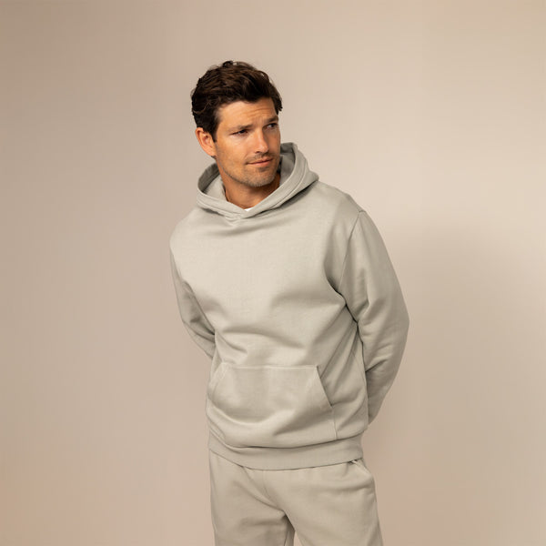 Man wearing a cotton fleece hoodie in Wolf Grey, front view.
