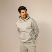 Man wearing a cotton fleece hoodie in Wolf Grey, front view.