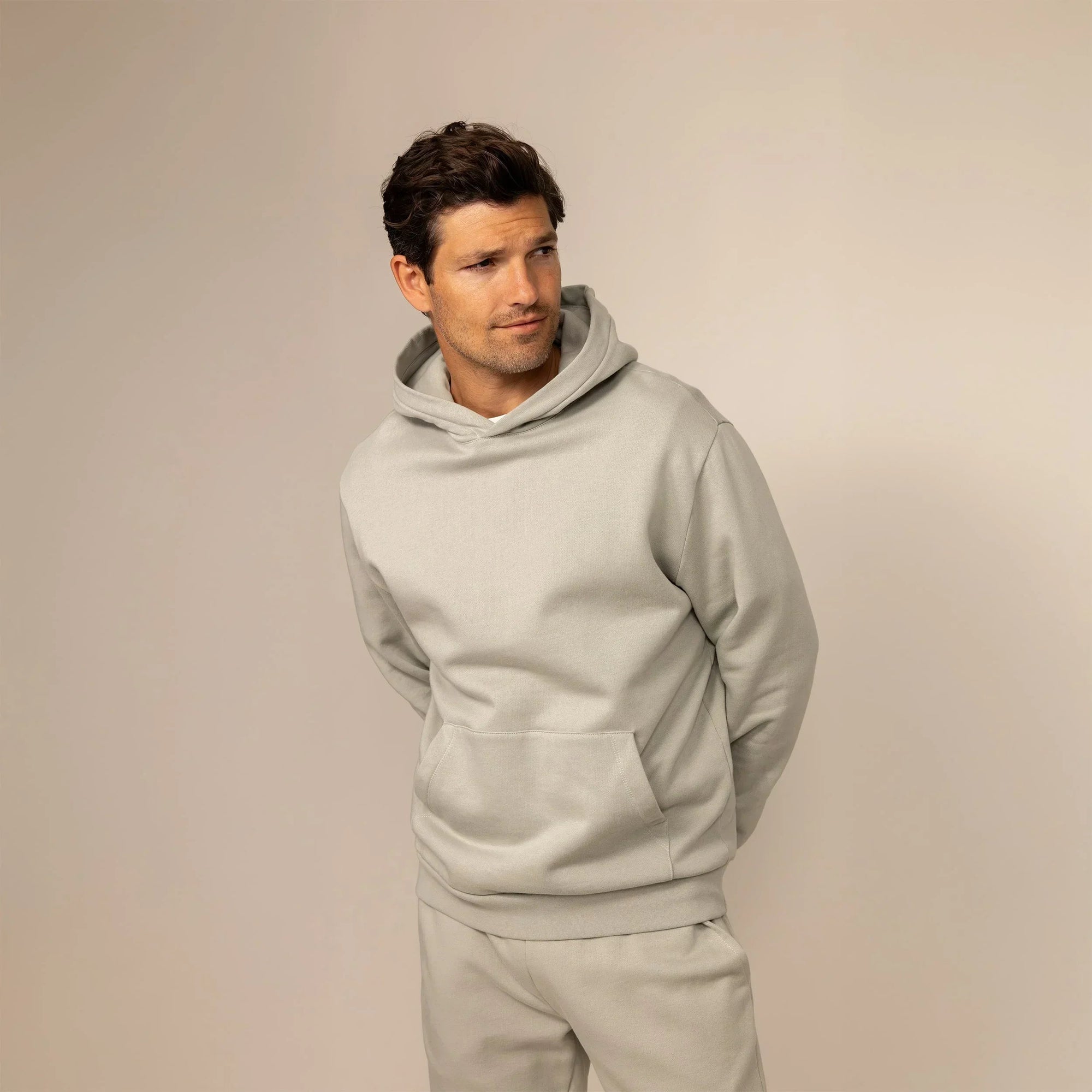 Man wearing a cotton fleece hoodie in Wolf Grey, front view.|wolf green