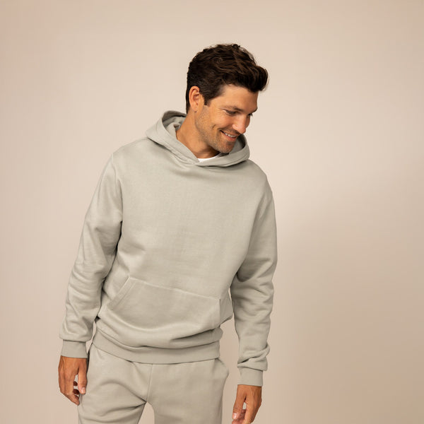 Man wearing a Marame cotton fleece hoodie in Wolf Grey, front view.