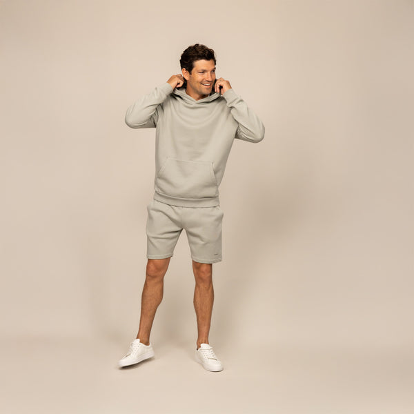 Man wearing a Marame cotton fleece hoodie in Wolf Grey, full view.