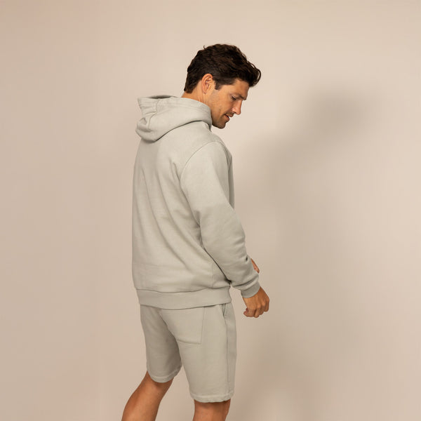 Man wearing a cotton fleece hoodie in Wolf Grey, rear view.