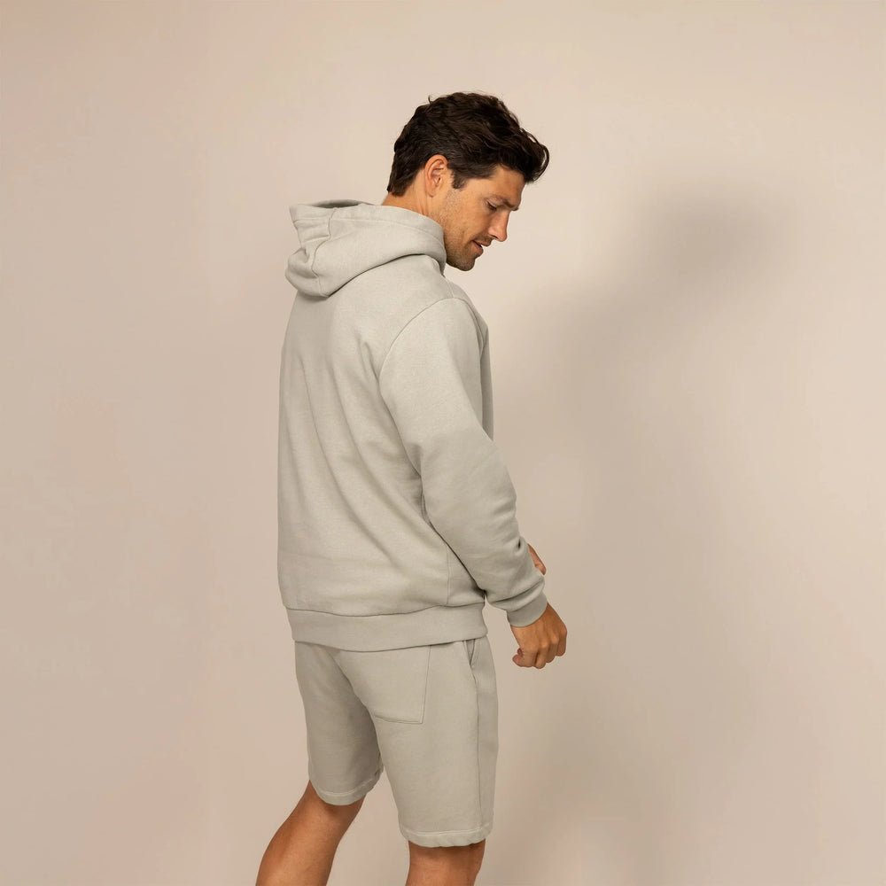 Man wearing a cotton fleece hoodie in Wolf Grey, rear view.