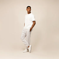 Man wearing Marame Cotton Fleece Joggers in Ash White, full view.