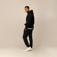 Man wearing Marame Cotton Fleece Joggers in Black, full view.