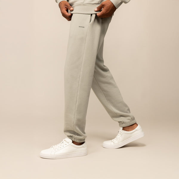Man wearing Marame Cotton Fleece Joggers in Wolf Grey, side view.