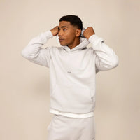 Man wearing a Marame cotton fleece Logo Hoodie in Ash White, front view.
