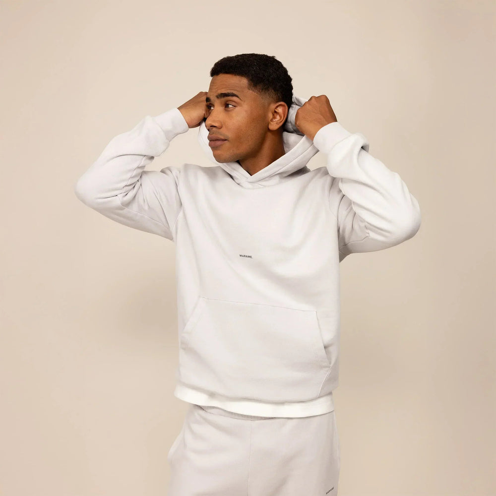 Man wearing a Marame cotton fleece Logo Hoodie in Ash White, front view.|ash white