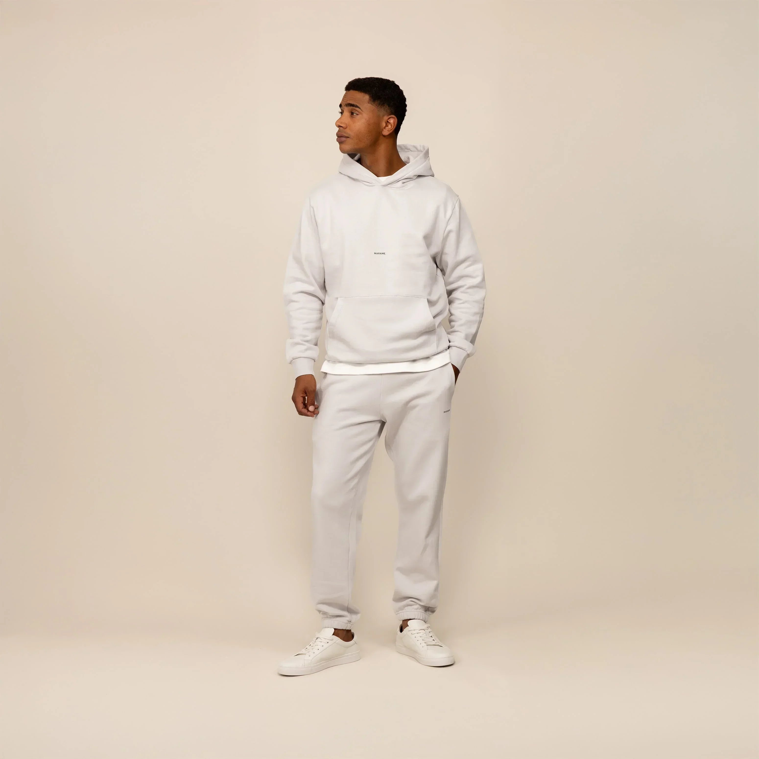 Man wearing a Marame cotton fleece Logo Hoodie in Ash White, full view.|ash white