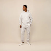 Man wearing a Marame cotton fleece Logo Hoodie in Ash White, full view.|ash white