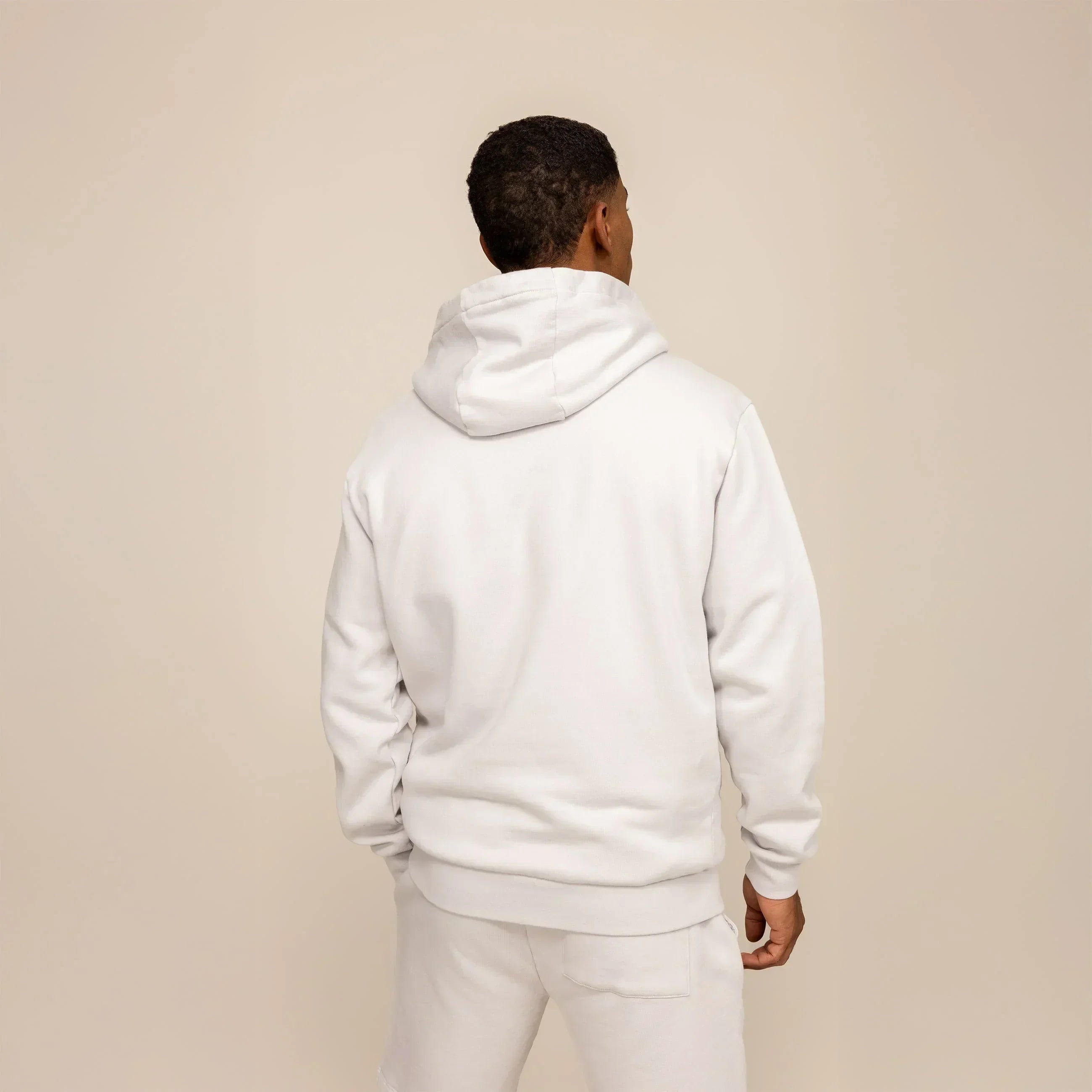 Man wearing a cotton fleece Logo Hoodie in Ash White, rear view.|ash white