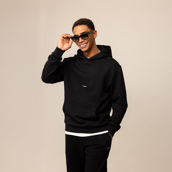 Man wearing a Marame Cotton Fleece Logo Hoodie in Black, front view.
