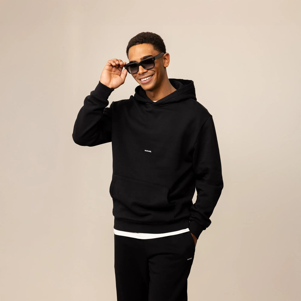 Man wearing a Marame Cotton Fleece Logo Hoodie in Black, front view.