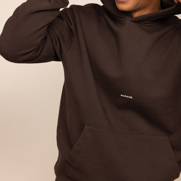 Man wearing a Marame cotton fleece Logo Hoodie in Smoked Brown, closeup